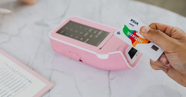 Driver tapping smartphone to contactless reader at parking pay station